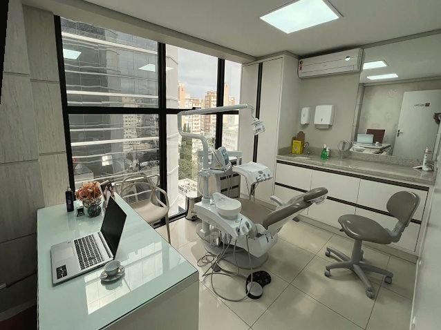 Sala de atendimento do consultório, com cadeira odontológica e janela ampla, no Centro de Florianópolis